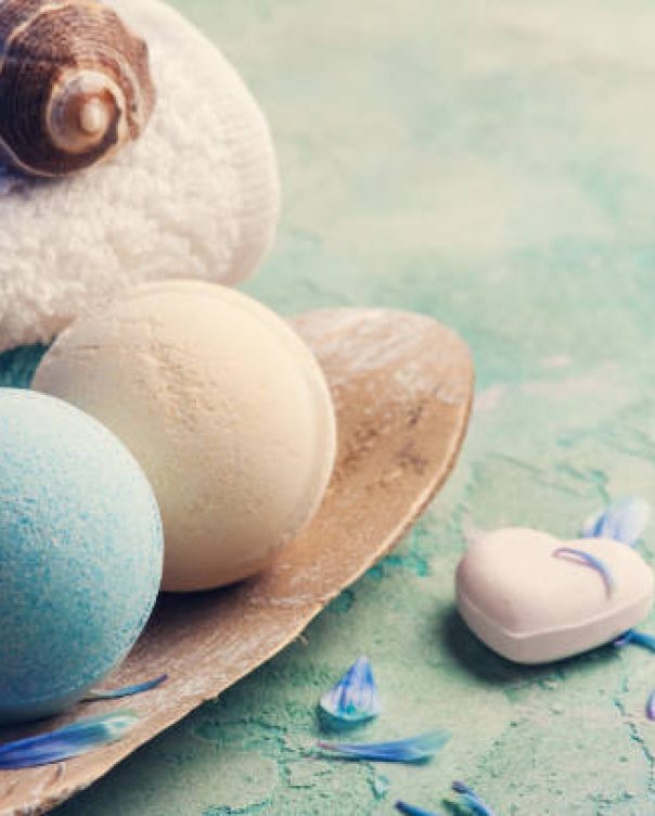 SPA treatment. Blue flowers and bath bombs on concrete background.